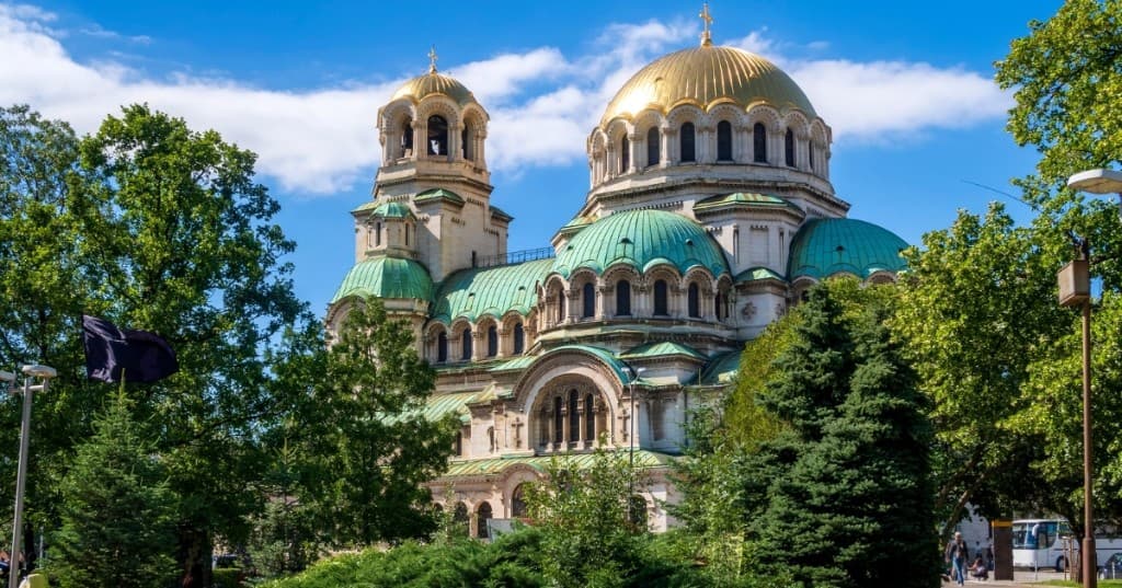 Sofya: İskender Nevski Katedrali, altın ve yeşil kubbeler, ağaçlarla çevrili parlak gökyüzü.