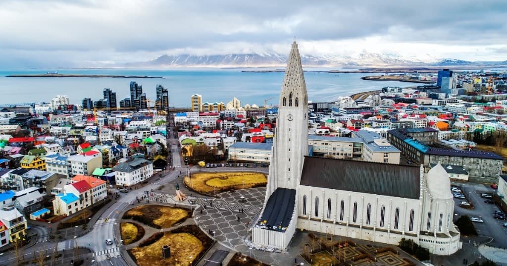 Reykjavik: Hallgrímskirkja kilisesi, renkli çatılı evler ve Faxaflói körfezi üzerinden kuşbakışı.
