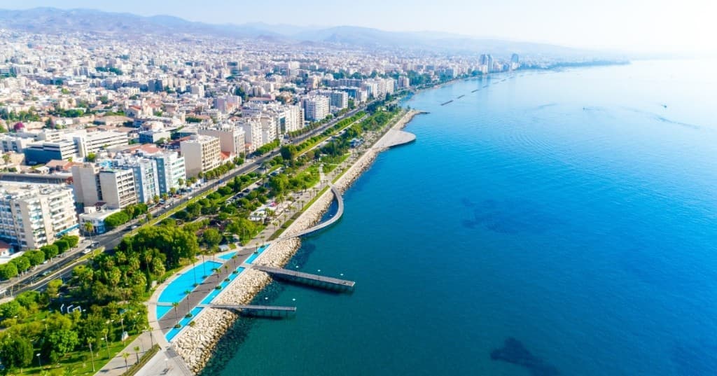 Limasol sahil şeridi: Molos yürüyüş yolu, palmiyeler, kıyıdaki binalar ve masmavi Akdeniz.